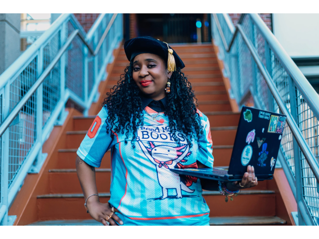 Woman standing on stairs with a laptop