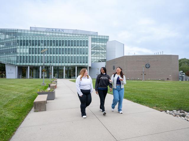 Three students walking across campus