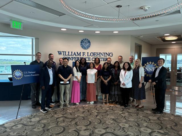 14 educators posing in an academic building