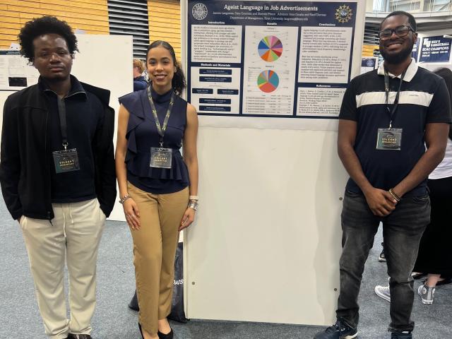 Three students around their Research Days poster
