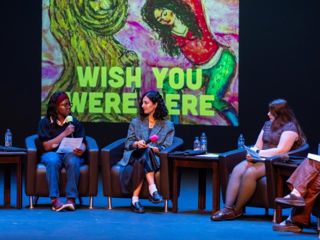 Three women speaking on stage