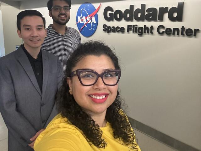 Woman taking a photo of herself and two males at NASA's Goddard Space Flight Center