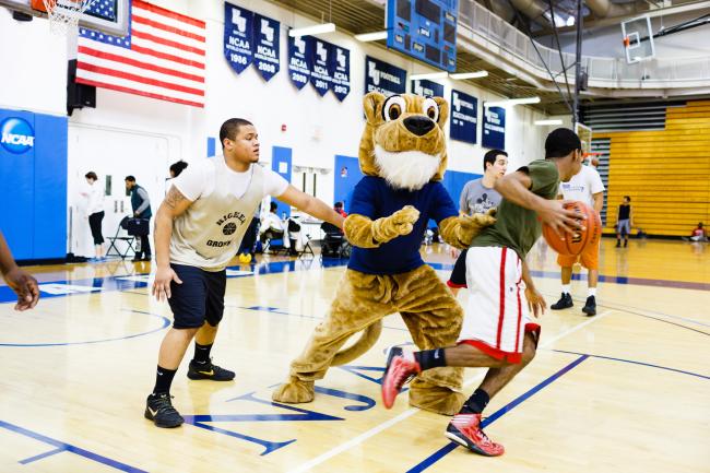 Kean University Cougar playing basketball with students