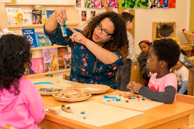 Kean student interacts with 2 children at Kean's Child Care Center