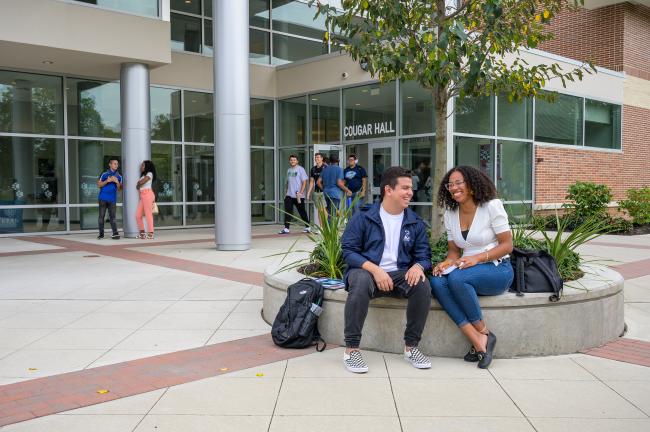 Kean students laugh outside of Cougar Hall