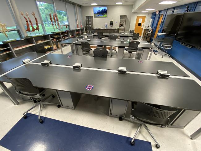 Photo of a Biology lab showing a sample of Cougar Care Stickers on the tables marking where you should NOT sit, so as to maintain social distancing.