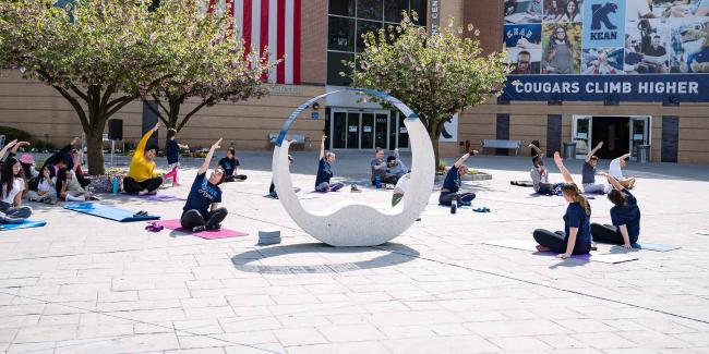 A yoga class being held outside of the Miron Student Center. 