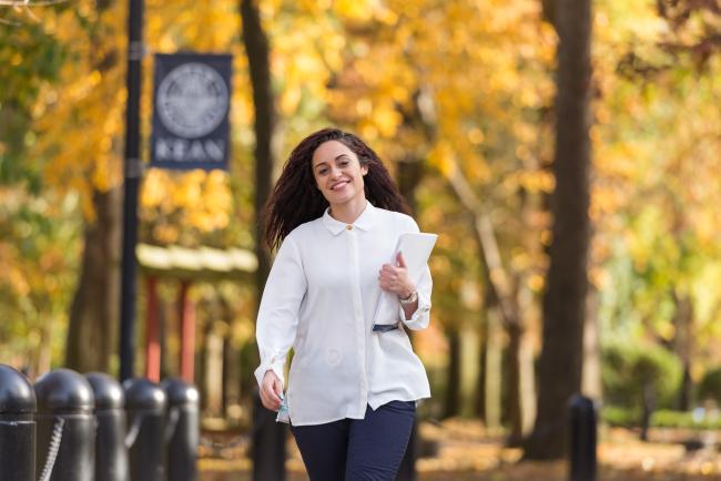 A Latina Kean student walks along Cougar Walk 