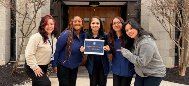 Students Standing and Holding Sign