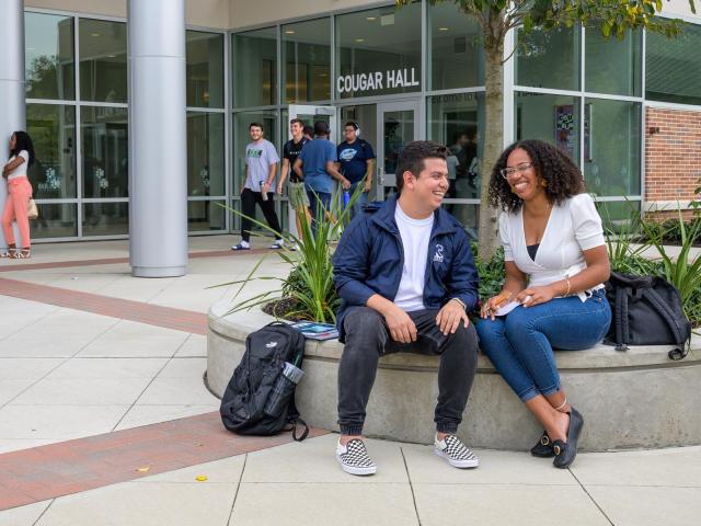 Kean students lounge in front of Cougar Hall