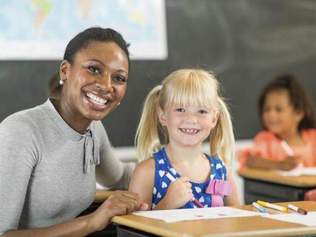 Teacher helps elementary student with course work