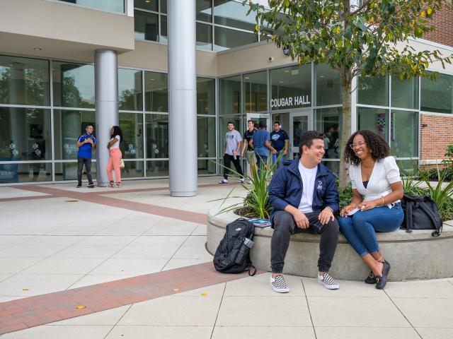 Kean students laugh outside of Cougar Hall