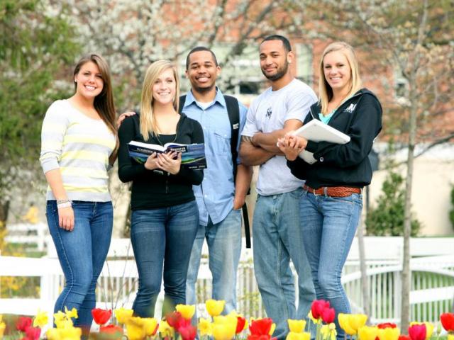 Kean students pose with tulips in the foreground. 