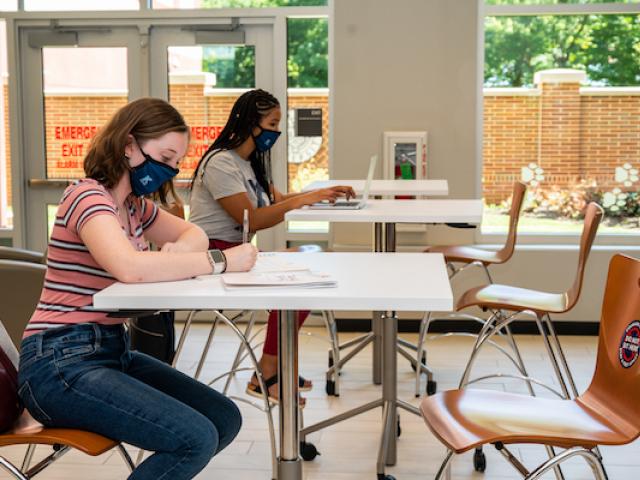 Students complete class work in an open study space