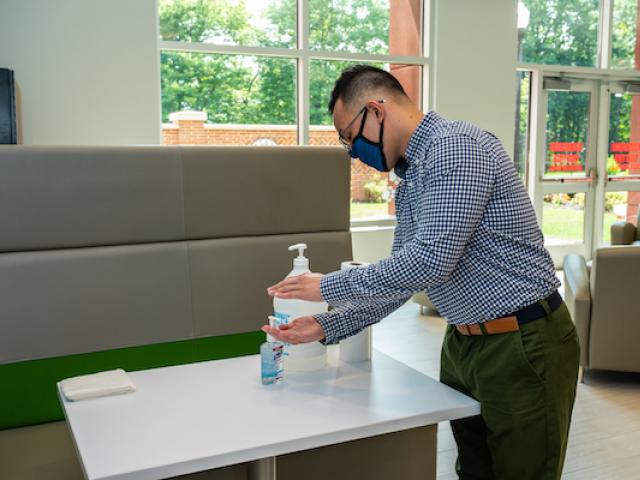 Student applies hand sanitizer