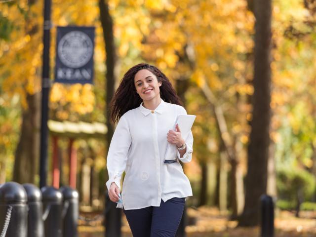 Kean student walks along Cougar Walk amidst fall color