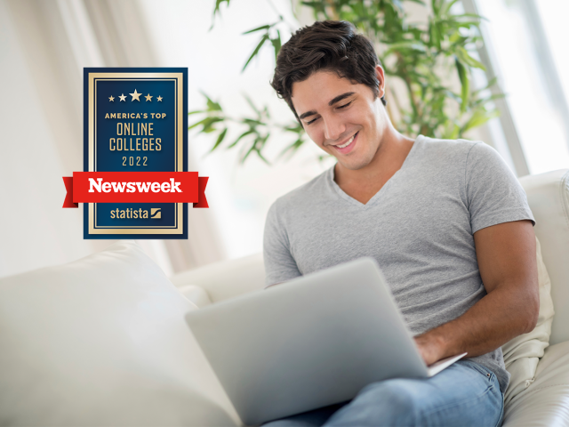 Young man studies on his laptop. Newsweek best online badge in the foreground. 