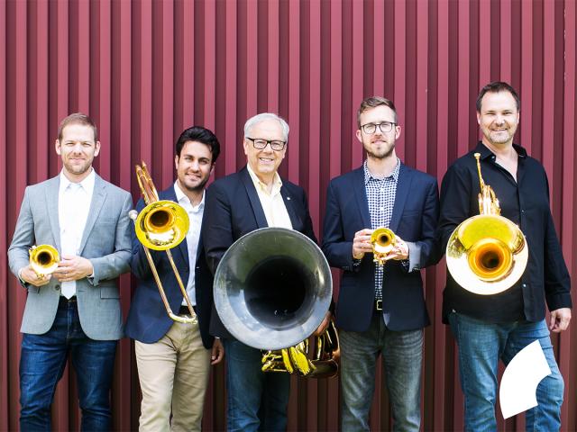 Five males from various ages with their brass instruments in hand