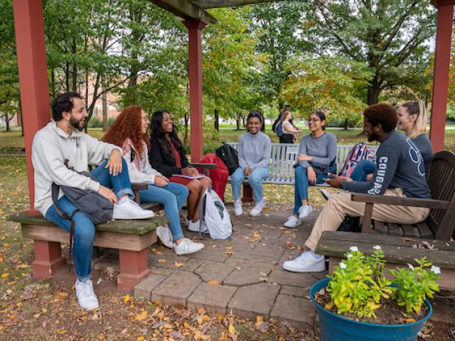 Kean students gather outside a pergola in the fall