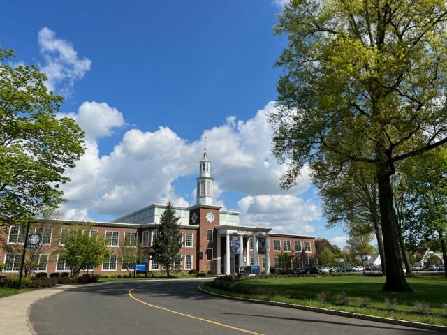 facade of East Campus building, shows the street and the trees surrounding it