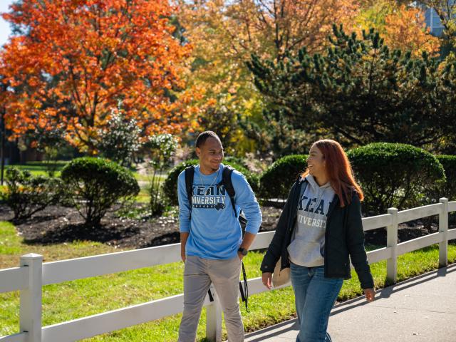 Two Kean students walk along Cougar Walk on a beautiful Fall day