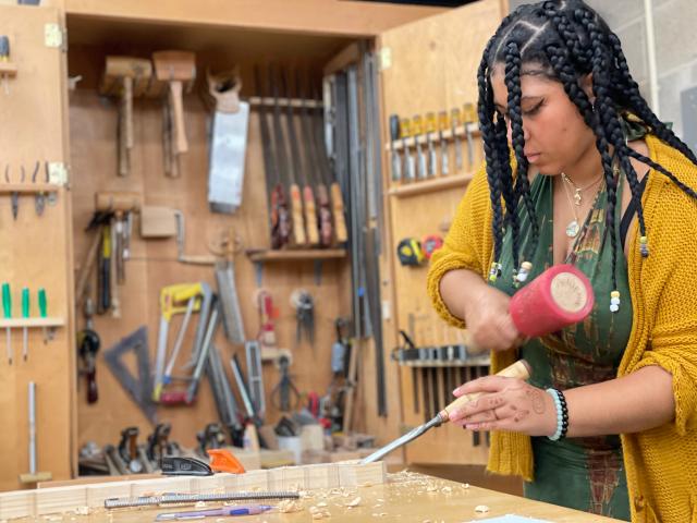 ean University Student, Ariana Barry, works on a sculpture in the Fine Art woodshop.