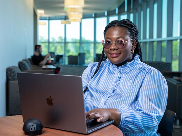 An adult learner is pictured with her laptop 