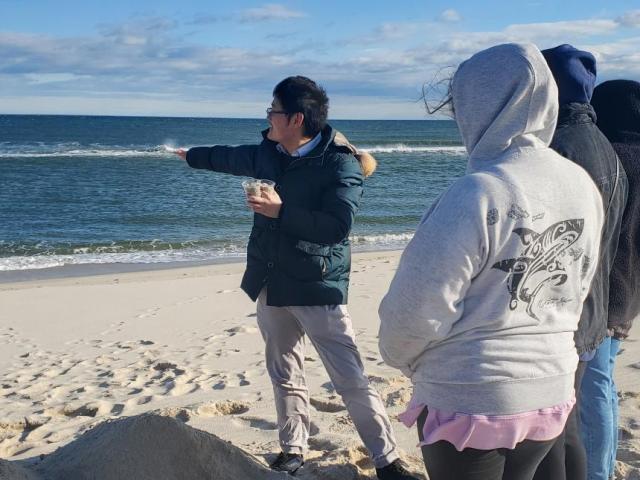 Dr. Cheng on the beach with class