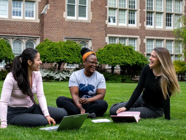Kean Jersey City students recline outside of Hepburn Hall 