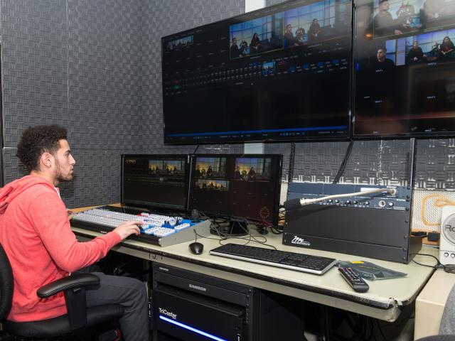A Kean media arts student editing content in Kean's TV studio