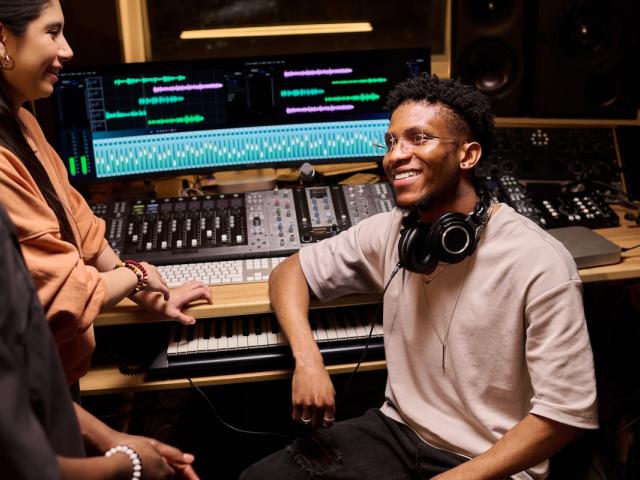 A young music producer does production work in his studio