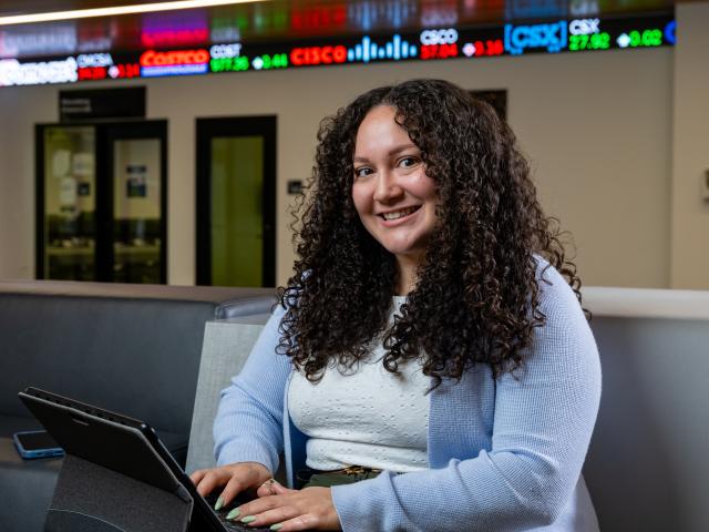 A financial technology student researches on her tablet. 