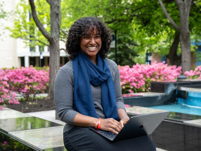 A Kean Jersey City student pictured on-campus with her laptop