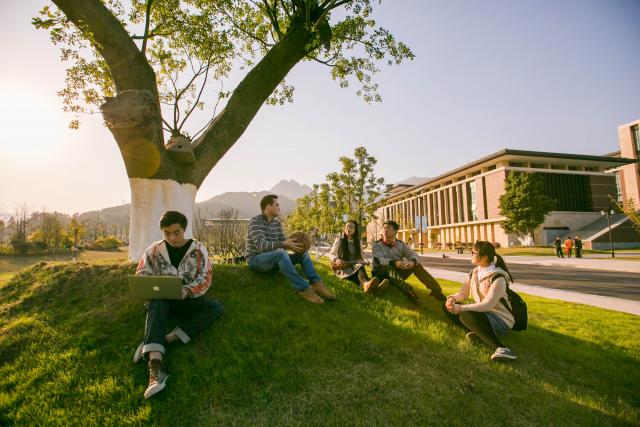 Wenzhou-Kean University students talking on the grass.