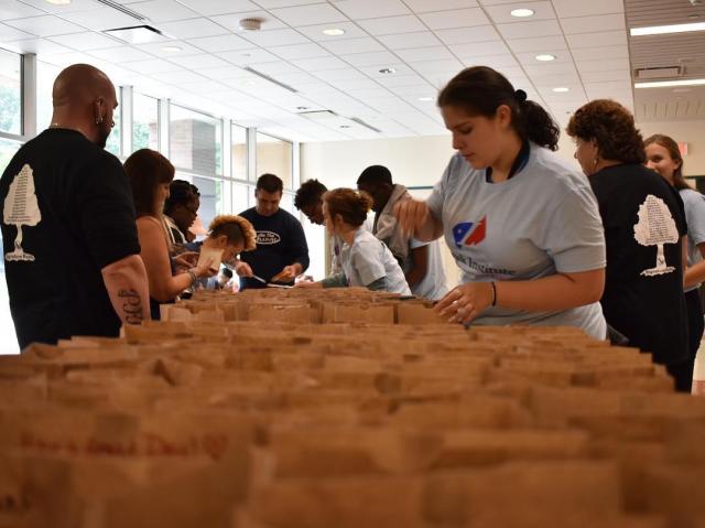 Volunteers make peanut butter and jelly sandwiches to be distributed to the homeless.