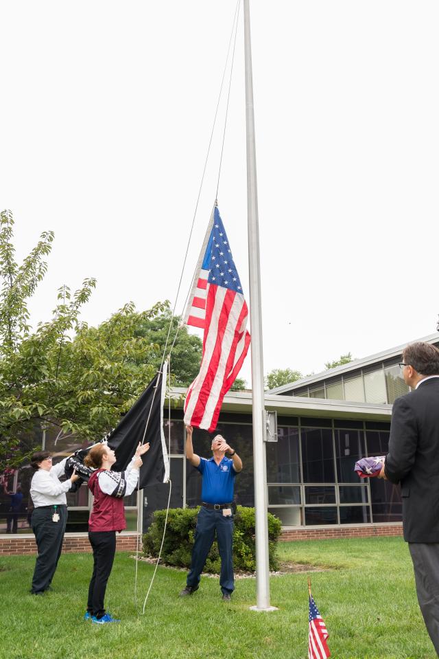 An American flag that flew over Ground Zero is raised at Kean University.