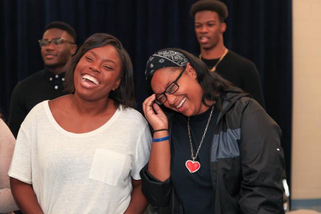 Choir members share a moment at rehearsal