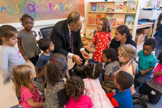 Dr. Farahi talks with a little girl as he's opening the gift. 