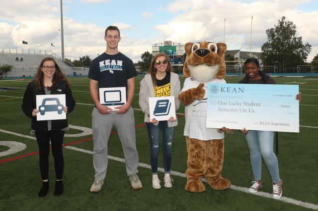 The winners of the grand prizes pose for a picture on the football field. 