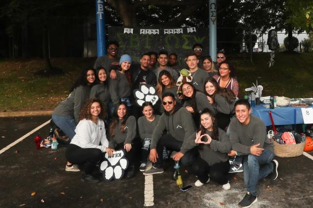 A group of Kean students pose for a picture at the booth they have set up at Homecoming 