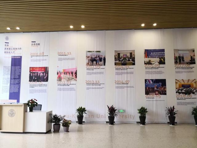 2018 China-US Education Forum in Wenzhou-Kean shows lobby with vertical posters documenting establishment of Wenzhou-Kean until today 2018
