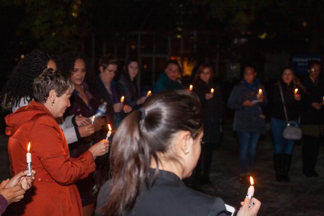 Kean students, actresses, the YWCA and others gather around with lit candles for a candlelight vigil outside of clock tower at Kean University