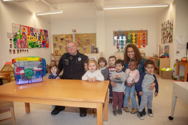 Sargent Mark Anacker and Keirah Tompkins pose with Teddy the hamster and the rest of the preschool class. 