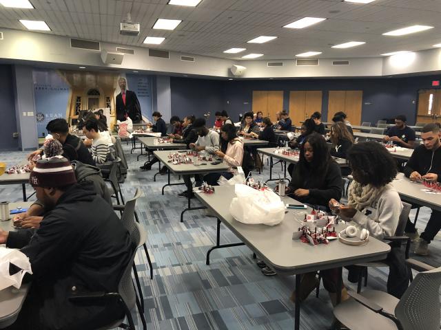 A whole room of students put together Salvation Army bells