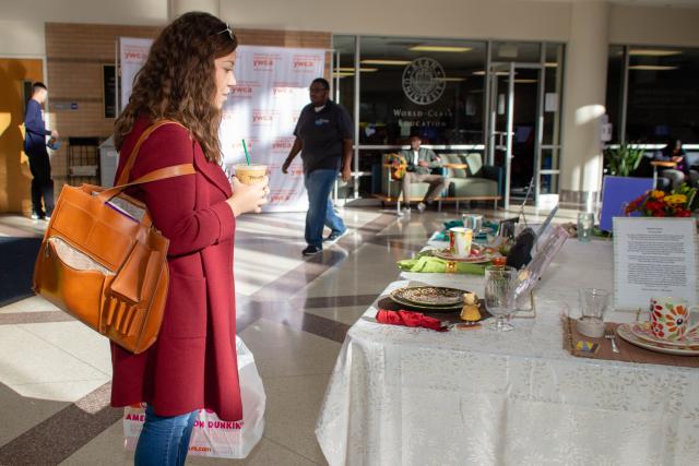 Kean student stands, looking at the Empty Place At The Table Art Display