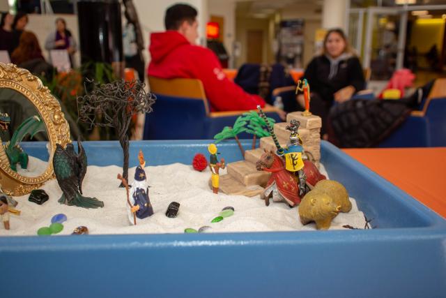 Children's sand art is displayed on a table to show what children's involved in domestic violence situations may do in therapy to express themselves.