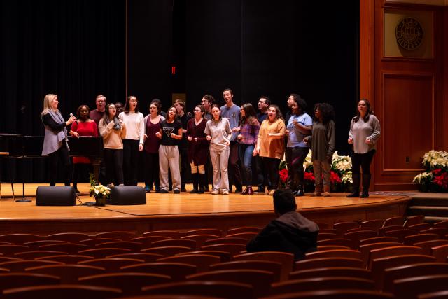 Kean Students and Kelli O'Hara stand on stage warming up for a big performance.