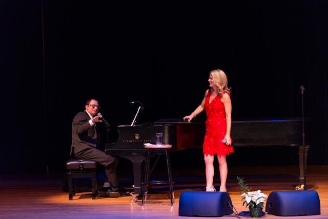 Kelli O'Hara stands on stage near the piano and pianist, Dan Lipton.