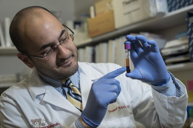 Dr. Yousseff Kousa ’05, ’07 M.S. examines a test tube in the lab