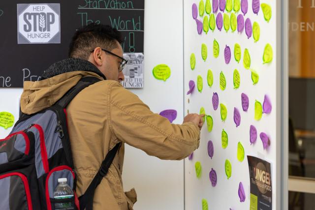 A Kean University student writes on the "Hunger Wall," which encourages students to think about hunger in the U.S.